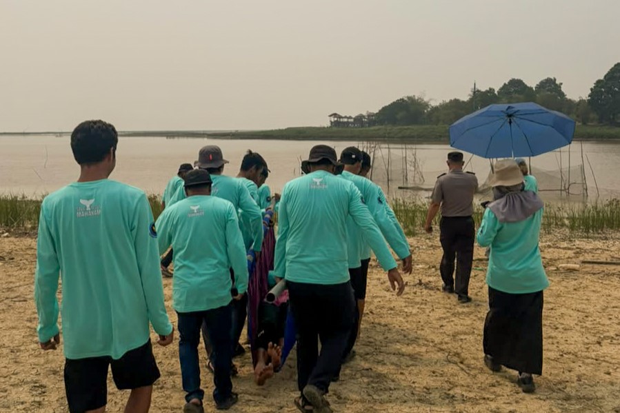 Foto 5. Partisipan kegiatan ‘menandu’ pesut Mahakam yang terdampar di darat lalu mengembalikannya ke perairan. (Foto oleh: Roni Irfan/Kampung Minta)