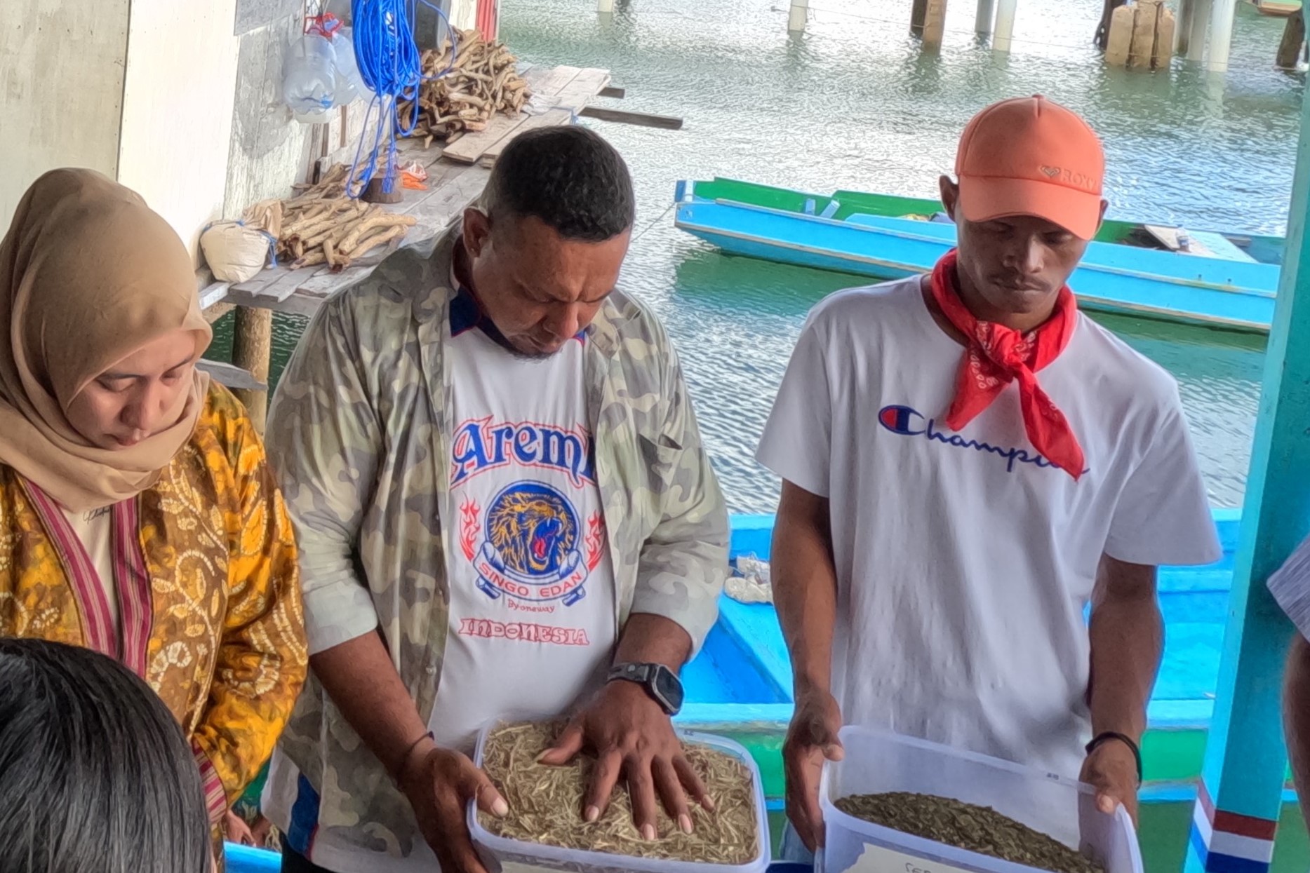 A joint prayer session before the trial; participants hold the mixed powder with high hopes, praying for the best results for seaweed cultivation. Photo: ©WWF-Indonesia/ Annisa S. Aulia