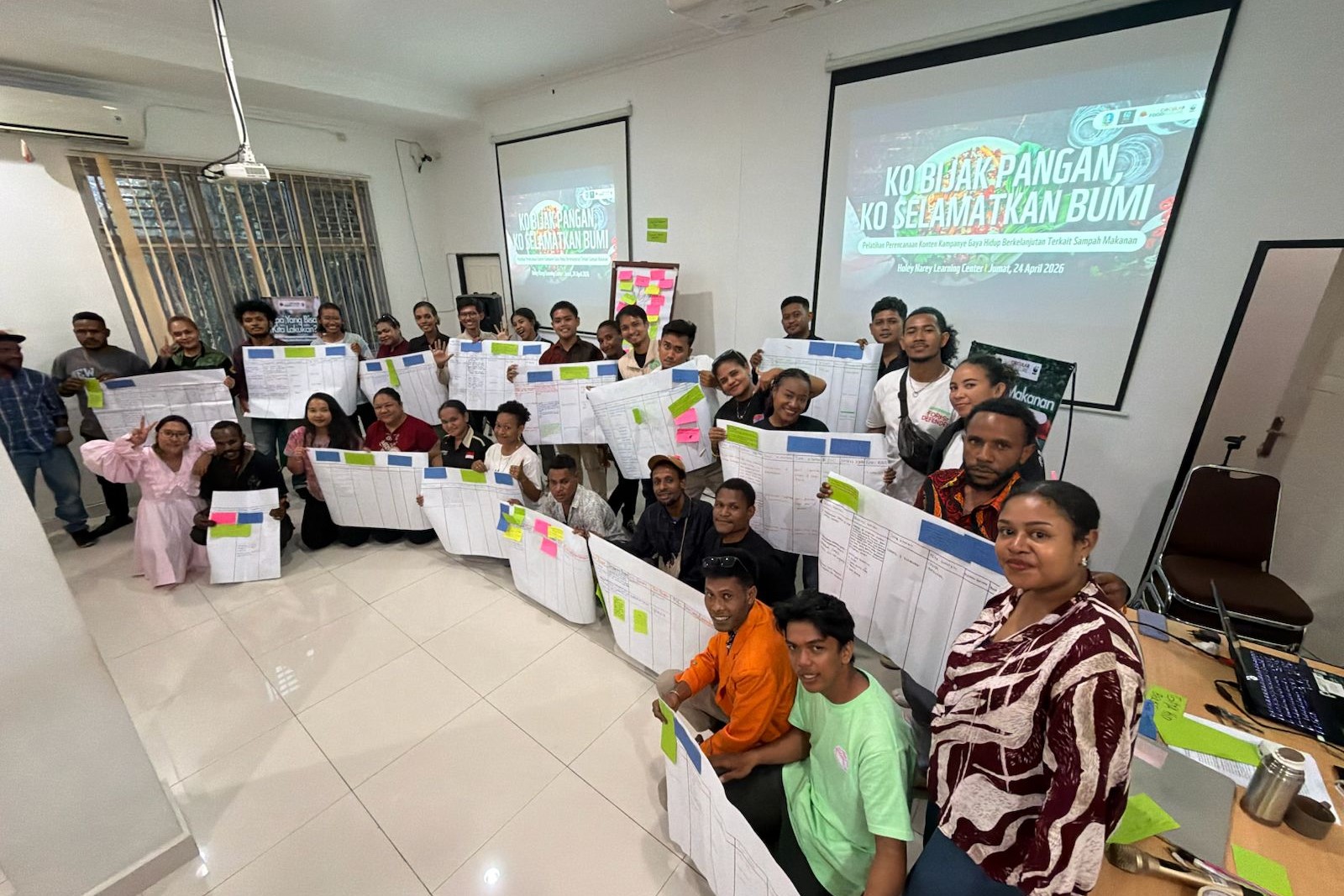 Foto Bersama Komunitas Peduli Lingkungan, Pemuda-Pemudi Lintas Agama, Masyarakat Adat, dan Rekan Mahasiswa sembari memegang kertas perencanaan konten kampanye yang telah disusun bersama-sama.